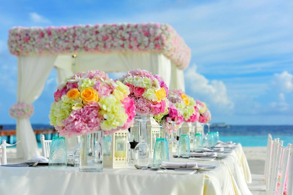 Beautiful seaside wedding setup with floral arrangements and pastel colors on a sunny day.